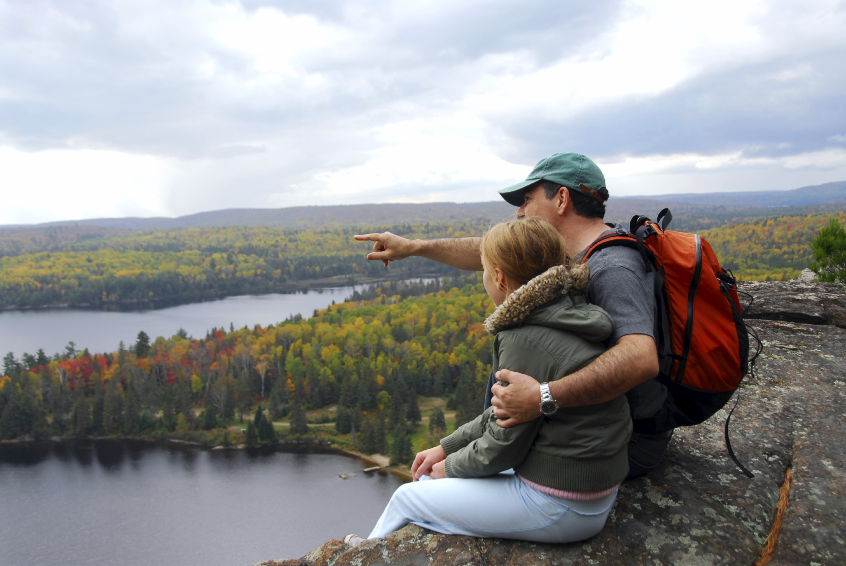 father and daughter looking out at the view after a hike